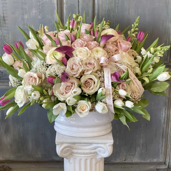 Large bouquet of pale pink and white roses with tulips in a white vase