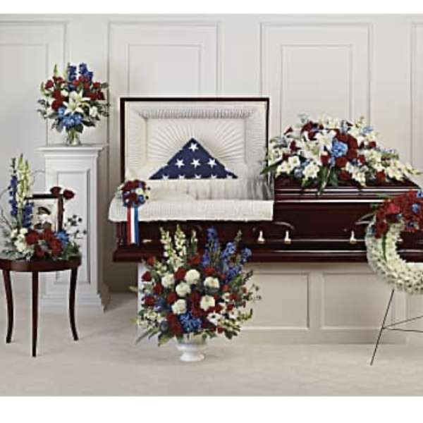 Funeral casket spray and wreath with red, white, and blue flowers