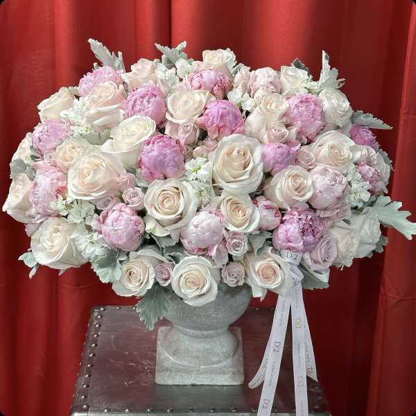 Large bouquet of pale pink and white roses in a gray vase