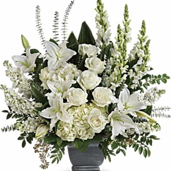 White lilies and roses arranged in a gray urn vase