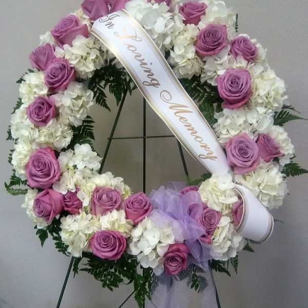 Pink rose and white hydrangea funeral wreath with a memorial ribbon