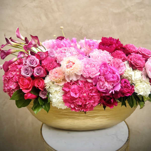 Pink and white floral arrangement in a gold bowl vase