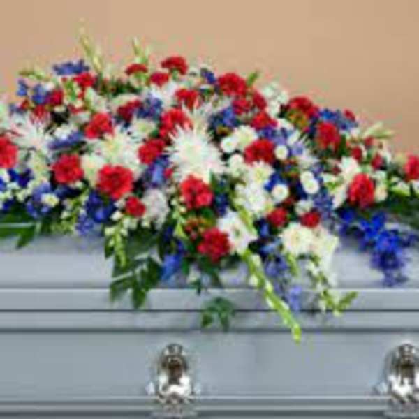 Red, white, and blue funeral spray on a casket