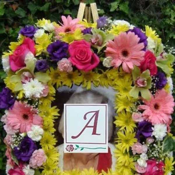 Colorful floral wreath with a monogram card in the center
