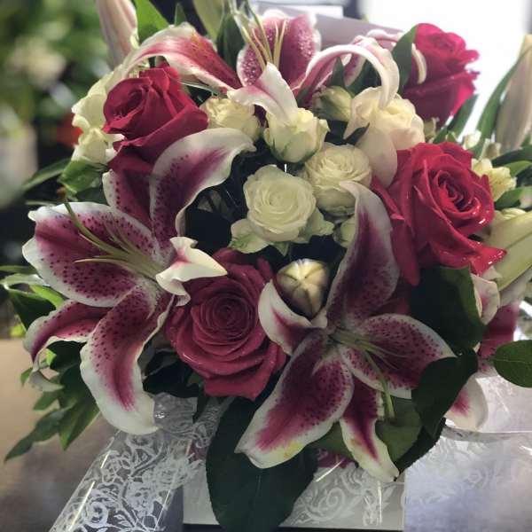 Bouquet of pink lilies and roses with white flowers