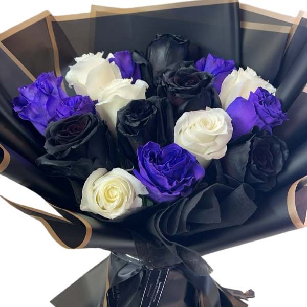 Bouquet of black, white, and purple roses wrapped in black paper