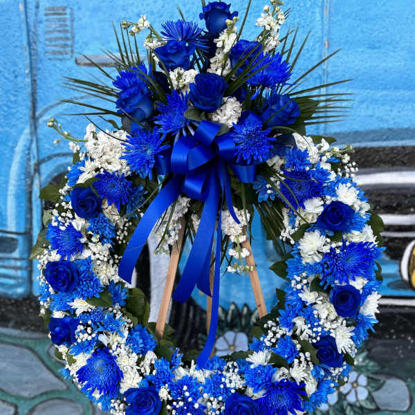 Blue and white floral wreath on a wooden easel with a ribbon bow
