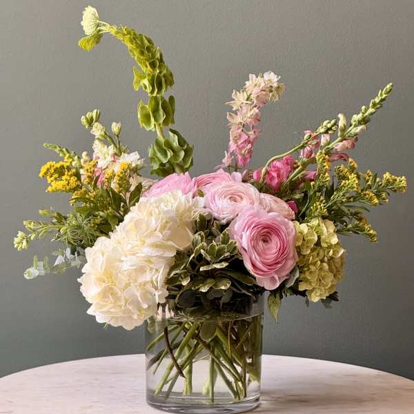 Pink and white mixed flowers arranged in a clear glass vase