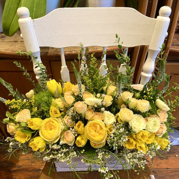 Yellow and cream floral arrangement on a chair