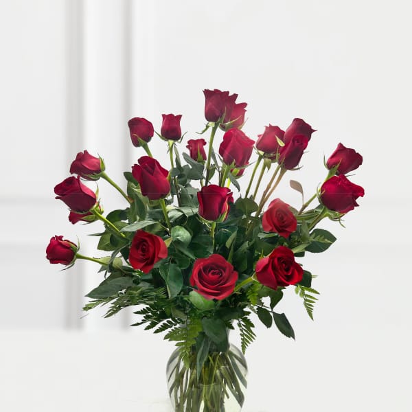 Red roses arranged in a clear glass vase