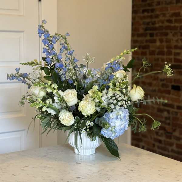 Blue and white floral arrangement in a white vase
