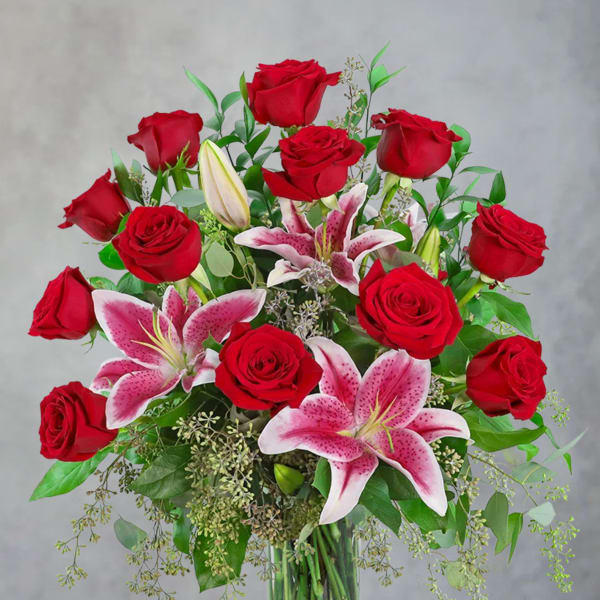 Red roses and pink lilies in a clear glass vase