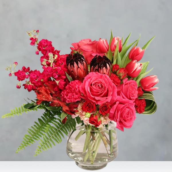 Pink and red mixed bouquet in a clear glass vase