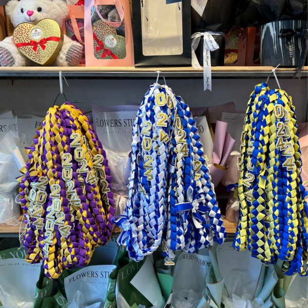 Braided graduation leis in purple-gold, blue-white, and blue-yellow.