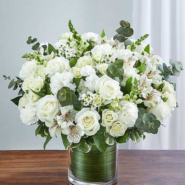 White roses and mixed white flowers in a glass vase