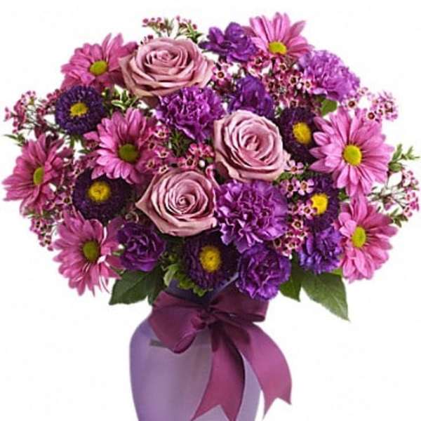 Pink and purple bouquet in a lavender vase with a ribbon