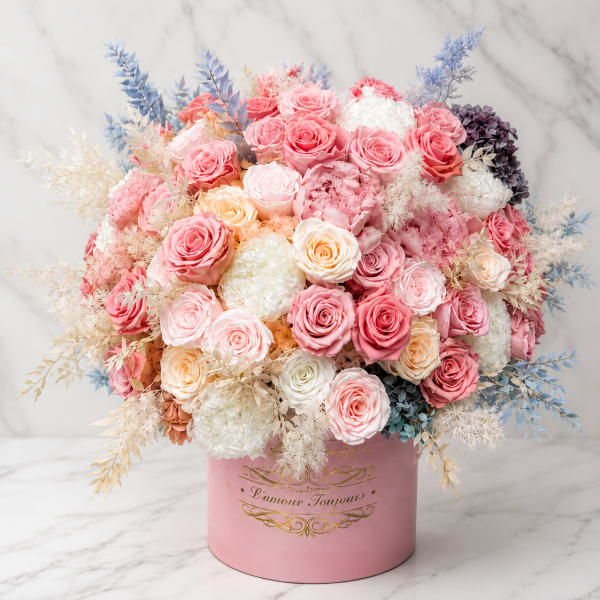 Pink and white rose arrangement in a round pink box