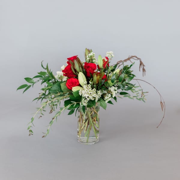 Red roses and white lilies in a clear glass vase