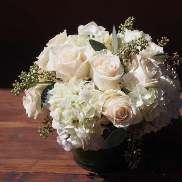 White rose and hydrangea bouquet in a dark vase