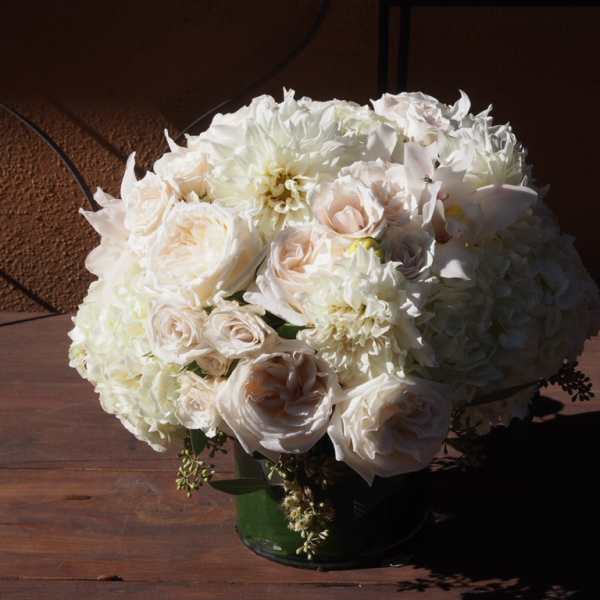 White roses and hydrangeas arranged in a green vase
