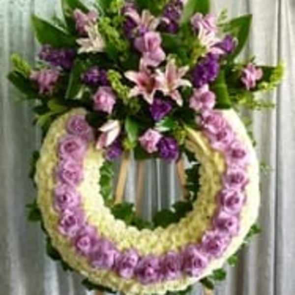 Standing floral wreath with pink and purple flowers on an easel