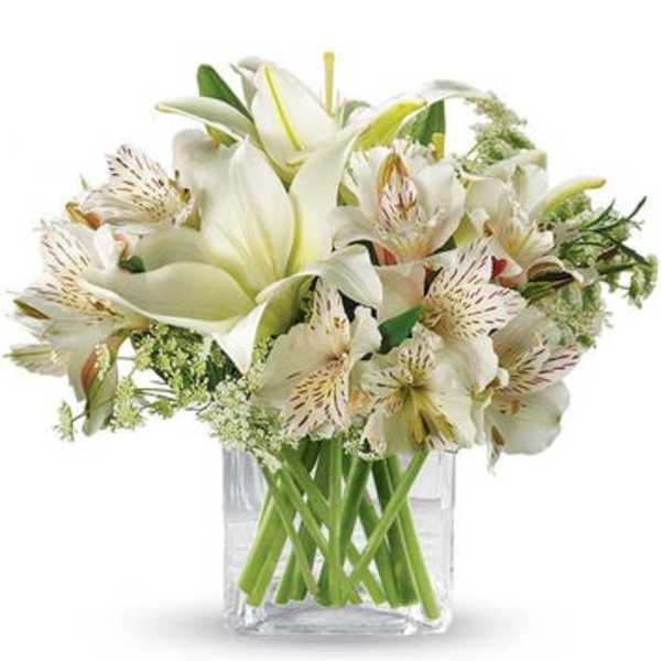 White lilies and alstroemeria in a clear glass vase