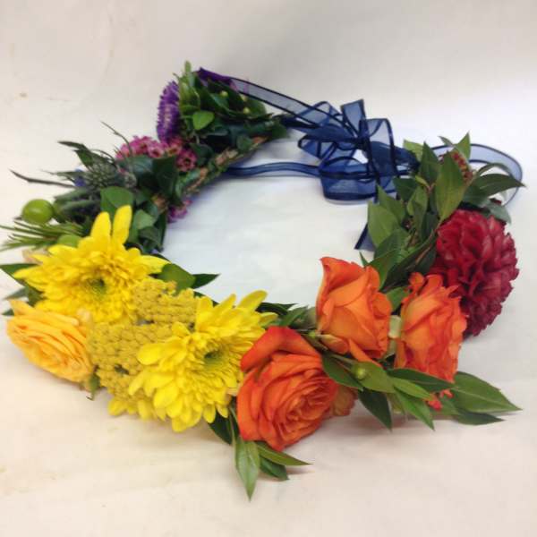 Colorful floral wreath with roses, chrysanthemums, and a blue ribbon