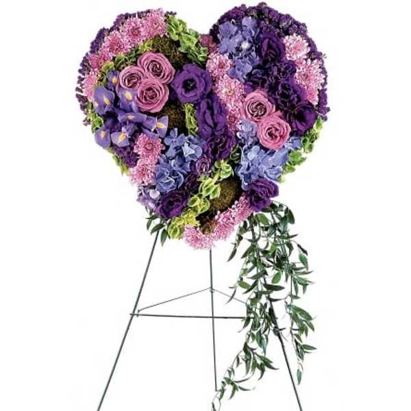 Heart-shaped floral standing spray in purple and pink tones on an easel