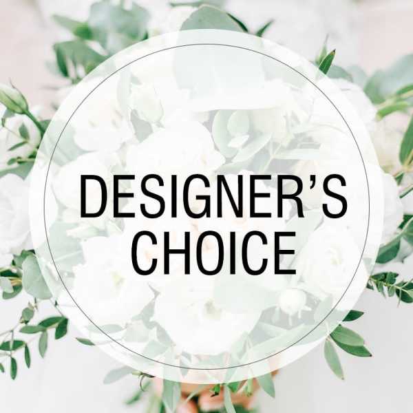 White floral arrangement with green foliage and a "Designer’s Choice" label