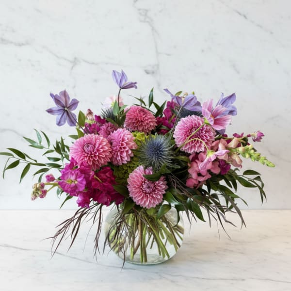 Pink and purple mixed bouquet in a clear glass vase