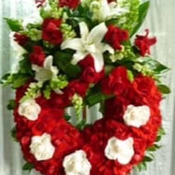 Heart-shaped red and white floral standing spray on an easel