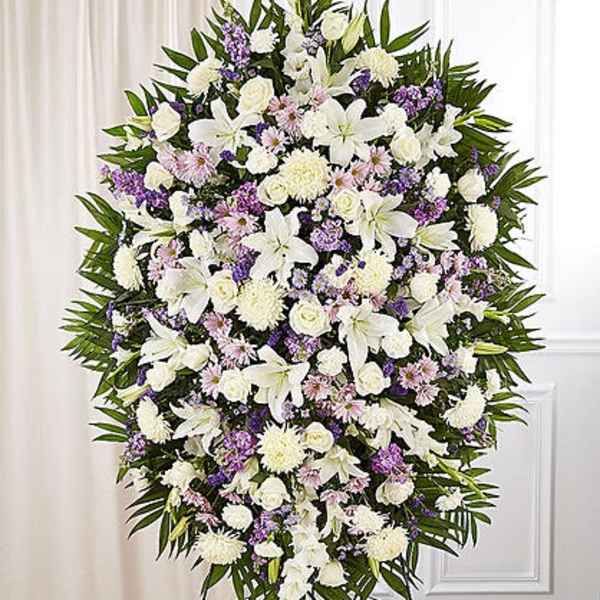 Large standing spray of white and lavender flowers on an easel