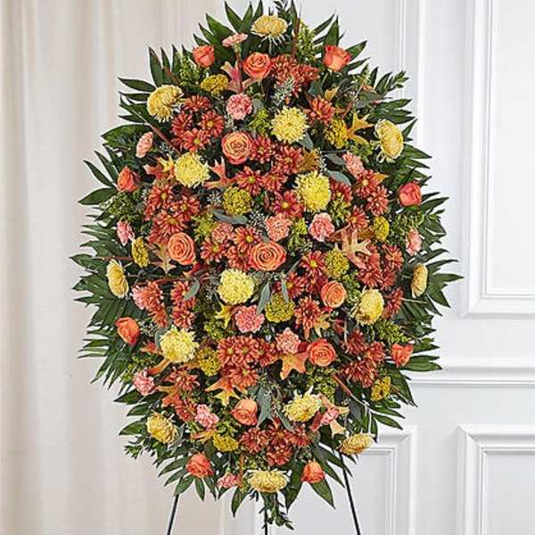 Large standing floral spray with orange, yellow, and pink blooms