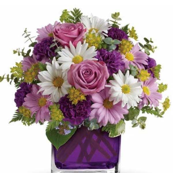 Pink roses and white daisies in a purple glass vase
