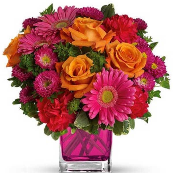 Bouquet of orange roses and pink daisies in a square glass vase