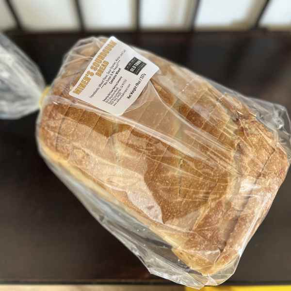 Loaf of sourdough bread in plastic wrap with a label