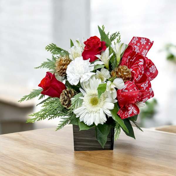 Red roses and white flowers in a black square vase with a red ribbon