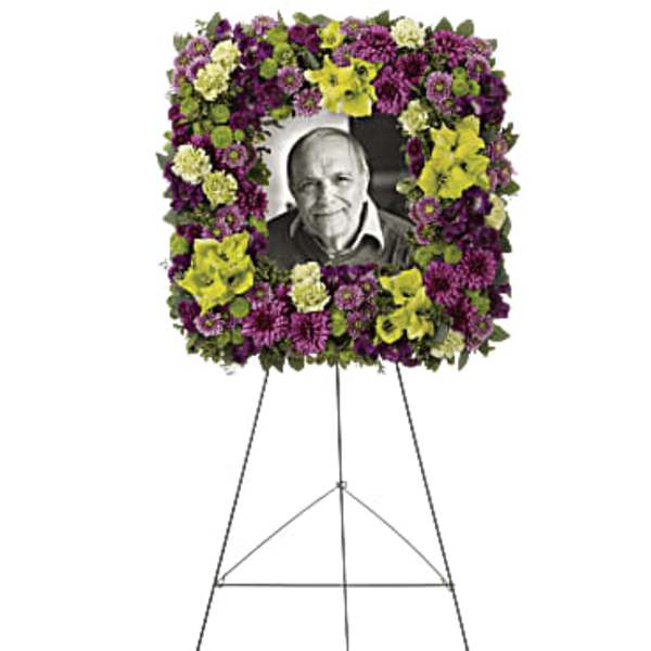 Standing floral wreath on an easel with a portrait in the center