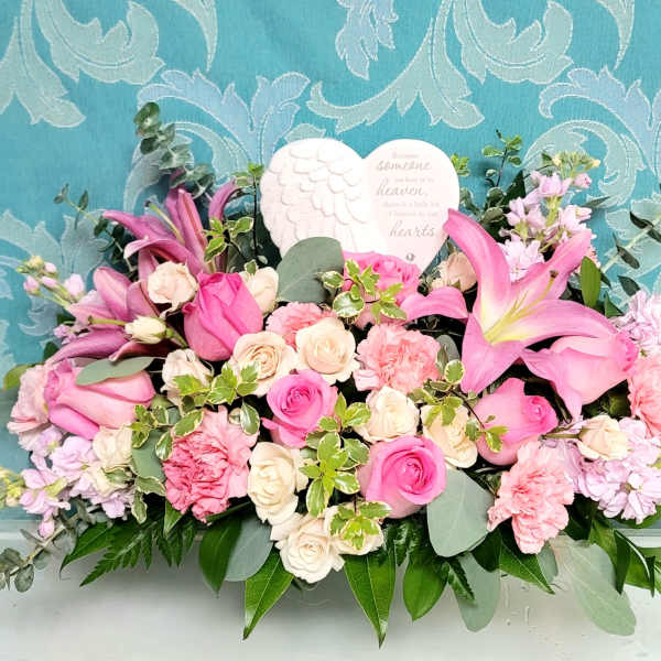 Pink and cream floral arrangement with lilies, roses, and a heart plaque
