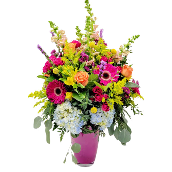 Colorful mixed bouquet in a pink vase with roses, gerbera daisies, and hydrangeas