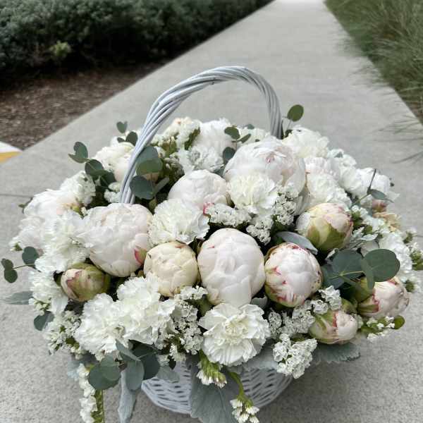White peony basket arrangement with eucalyptus and a woven handle