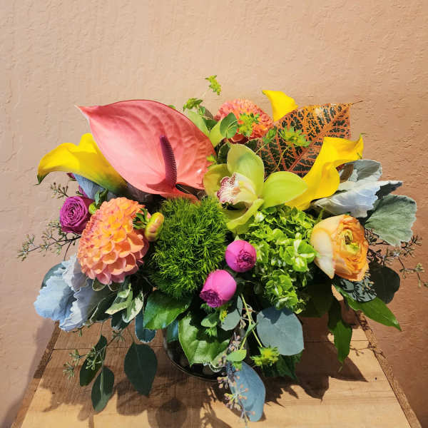 Colorful mixed floral arrangement with calla lilies, anthurium, and dahlias in a vase