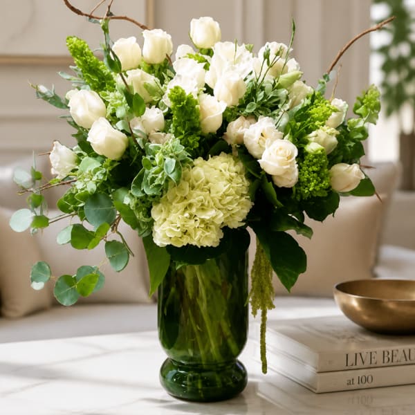 White roses and hydrangea in a green glass vase