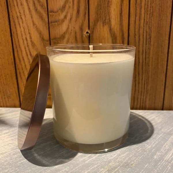 White candle in a clear glass jar with a metal lid