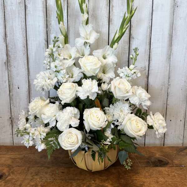 White roses and gladiolus in a pumpkin-shaped container