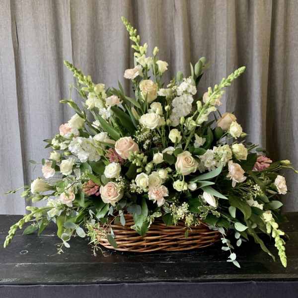 Large basket arrangement of pale roses and white flowers