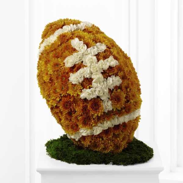Floral standing spray with orange and white flowers on a green base