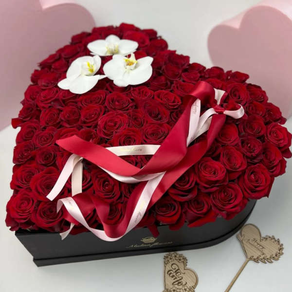 Heart-shaped box filled with red roses and white orchids