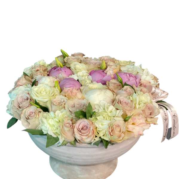 Pastel roses and peonies arranged in a low pedestal bowl