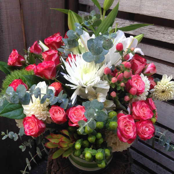 Bouquet of pink roses and white lilies in a vase with eucalyptus
